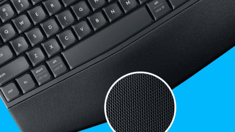 Nahaufnahme einer schwarzen Tastatur mit integrierter Handballenauflage und Detailansicht der strukturierten Stoffoberfläche