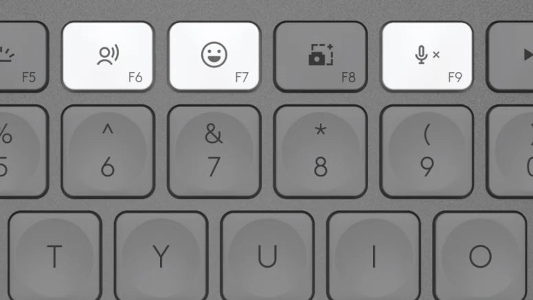 Nahaufnahme der Laptop-Tastatur mit beleuchteten Funktionstasten für Emoji, Diktieren und Stummschaltung.