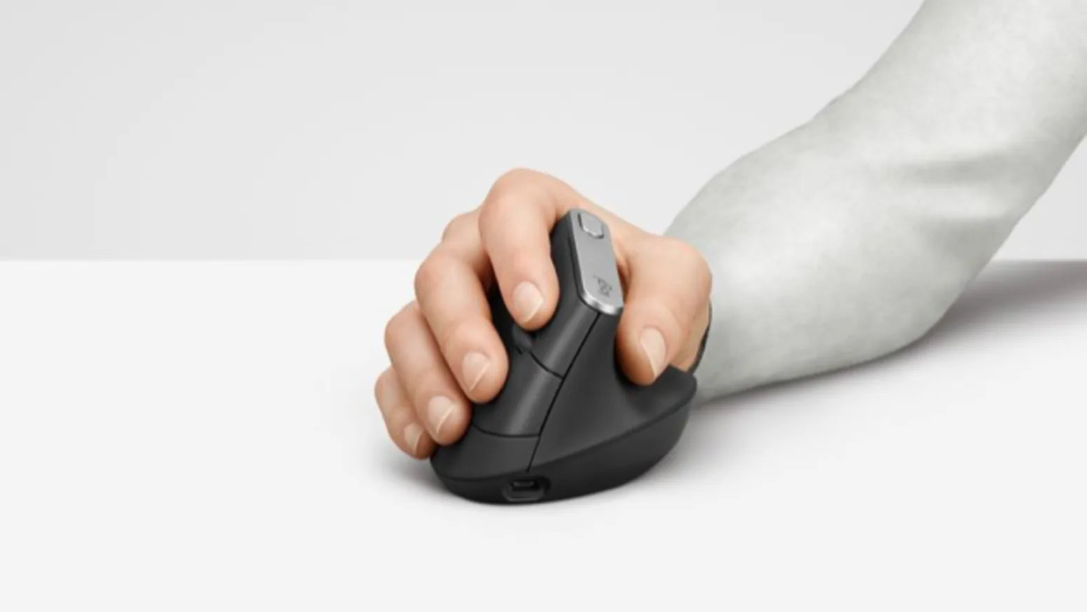 Hand bedient eine ergonomische vertikale Wireless-Maus in dunklem Grau auf hellem Schreibtisch