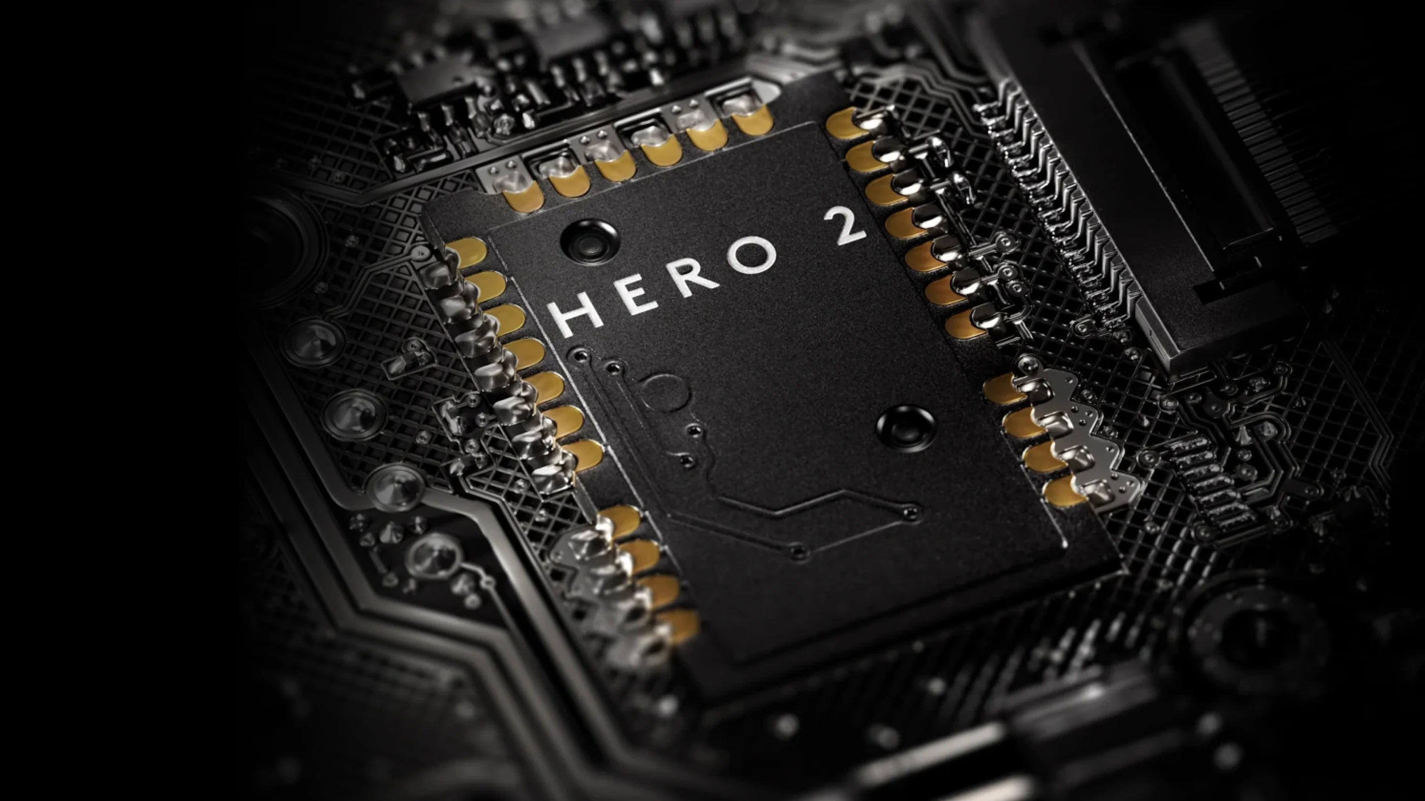 Nahaufnahme eines Hero 2 Computerchips mit vergoldeten Kontaktelementen auf einer schwarzen Hauptplatine.