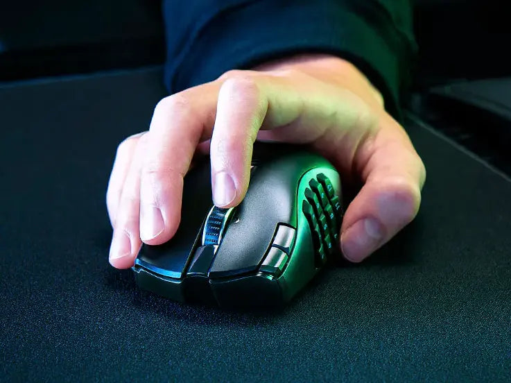 Hand bedient eine ergonomische Gaming-Maus mit Daumentasten auf einem schwarzen Mauspad.