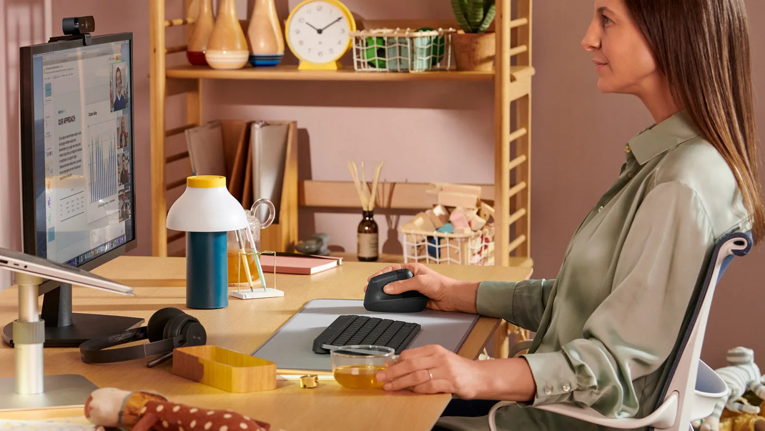 Frau arbeitet ergonomisch mit vertikaler Maus und kompakter Tastatur im Homeoffice
