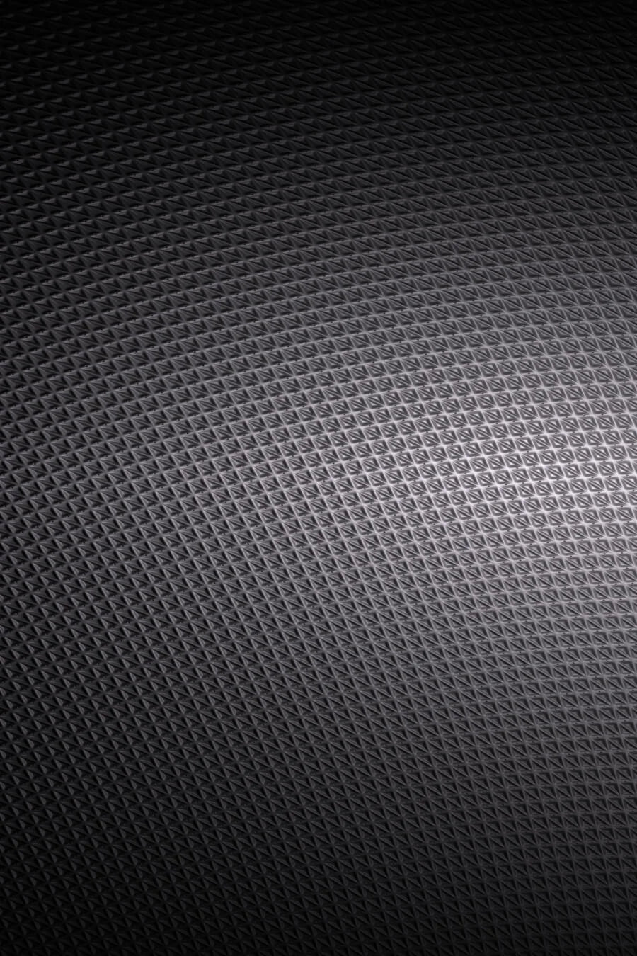 Detailaufnahme der dunklen, strukturierten Oberfläche eines Gaming-Laptops mit feinem Rautenmuster