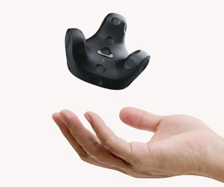 Schwebender VR-Tracker über einer offenen menschlichen Hand vor hellem Hintergrund.